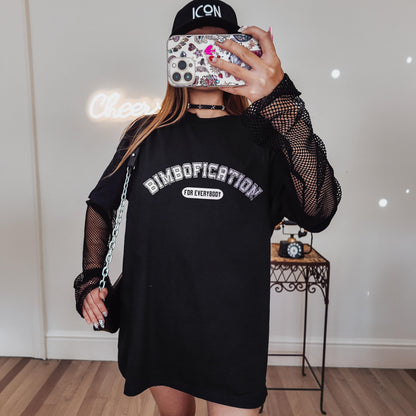 Woman wearing a black t-shirt with &amp;quot;DIMBOFICATION FOR EVERYBODY&amp;quot; text and mesh sleeves.