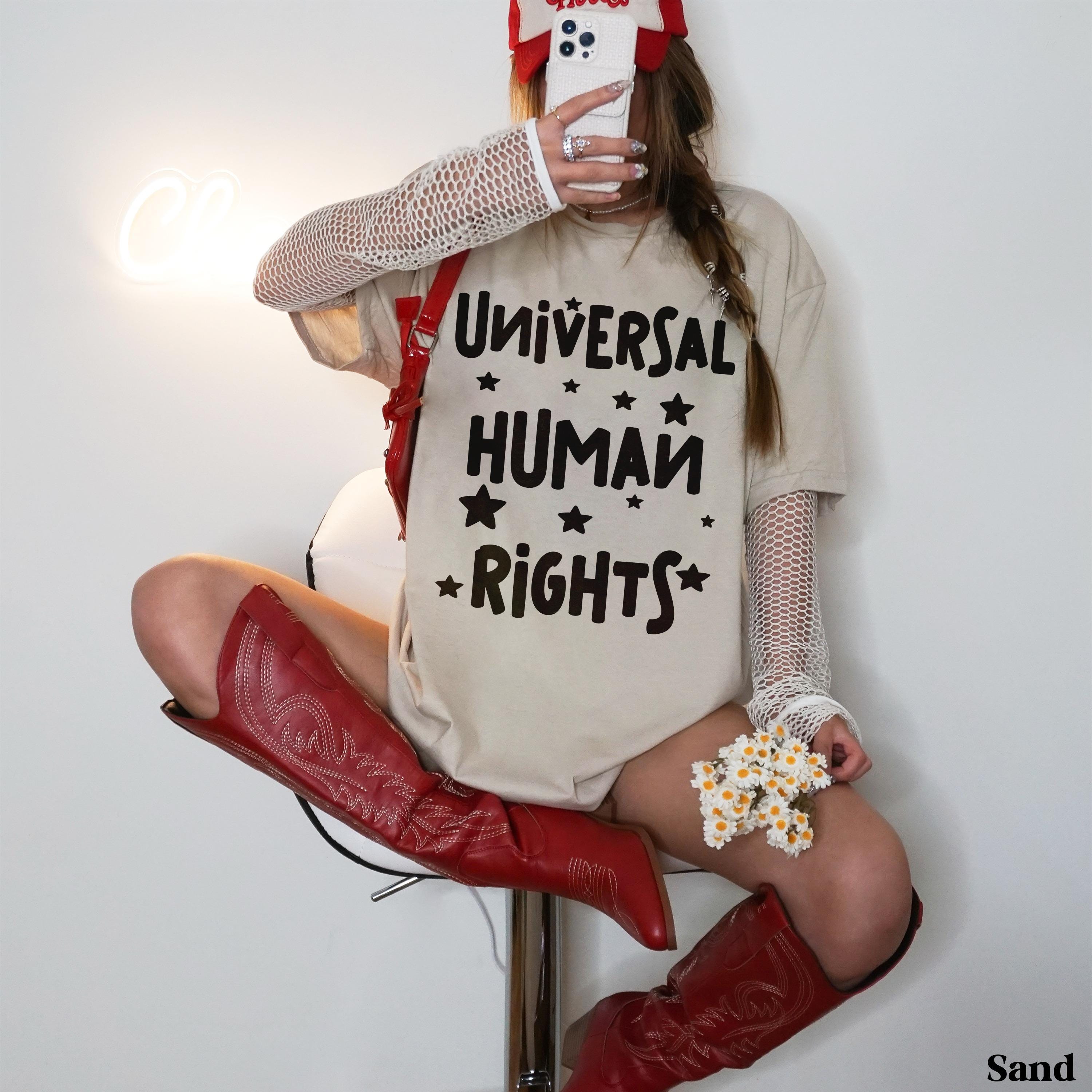 T-shirt with &amp;quot;Universal Human Rights&amp;quot; text, worn by a seated person in red boots.