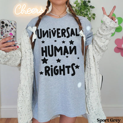 Grey t-shirt with &amp;quot;Universal Human Rights&amp;quot; text and white stars, worn by a person.