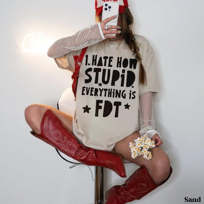 Woman wearing tan graphic tee with &amp;quot;I HATE HOW EVERYTHING IS FDT&amp;quot; text and red cowboy boots.