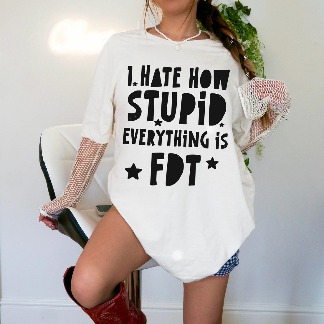 White oversized t-shirt with black text &amp;quot;I HATE HOW STUPID EVERYTHING IS FDT&amp;quot; and stars.
