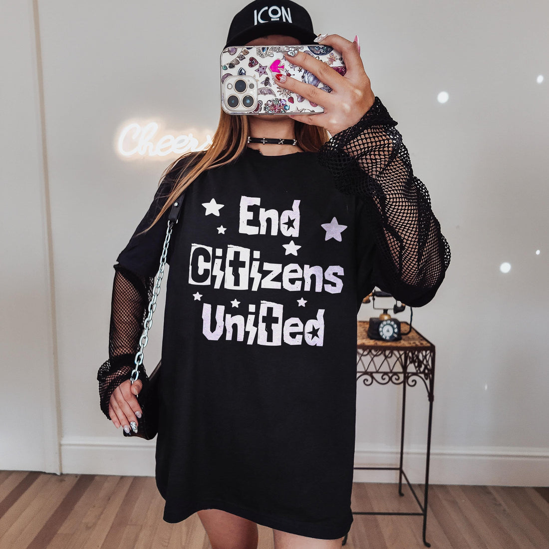 Black t-shirt with &amp;quot;End Citizens United&amp;quot; and star graphics, worn by a person holding a phone.