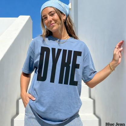 Woman wearing blue t-shirt with large black &amp;quot;DYKE&amp;quot; text.
