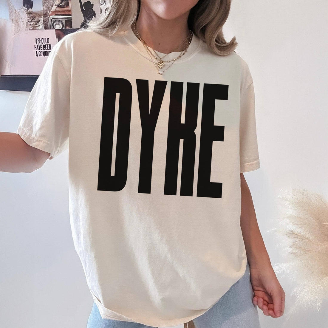 Cream t-shirt with bold black text spelling &amp;quot;DYKE&amp;quot;.