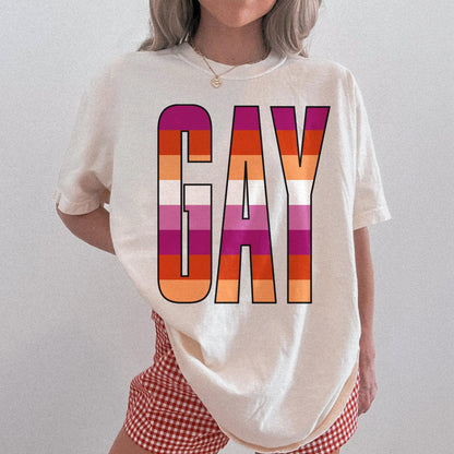 Cream t-shirt with &amp;quot;GAY&amp;quot; in the lesbian pride flag colors.