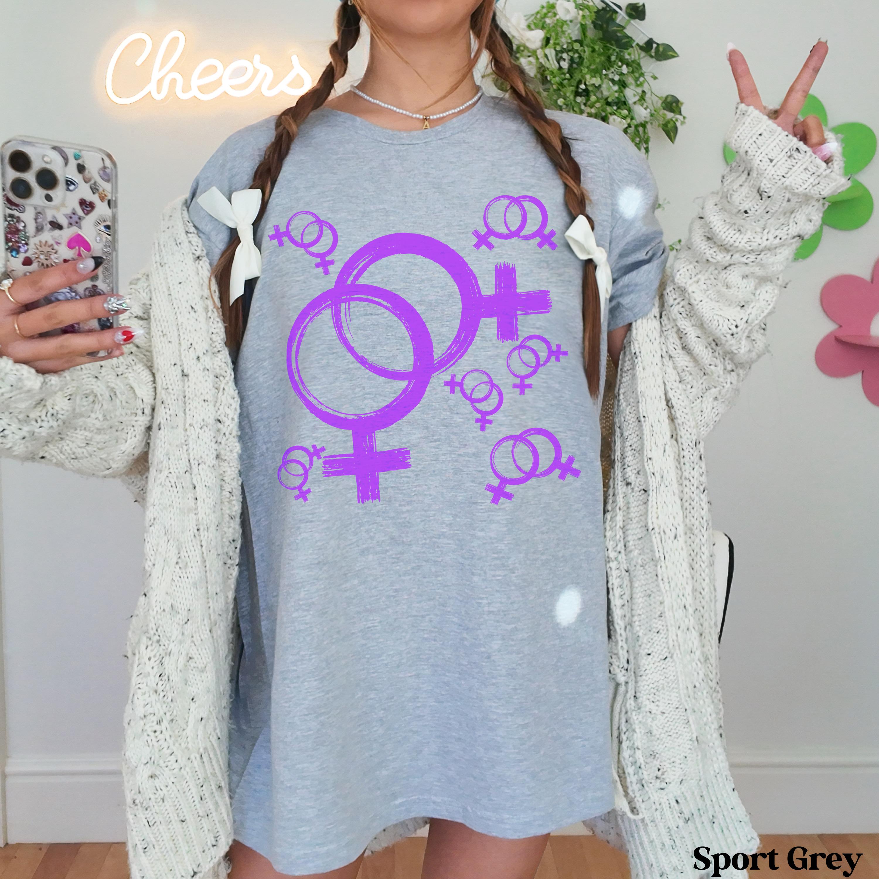 Light grey t-shirt with purple female symbols and smaller female symbols and bows.
