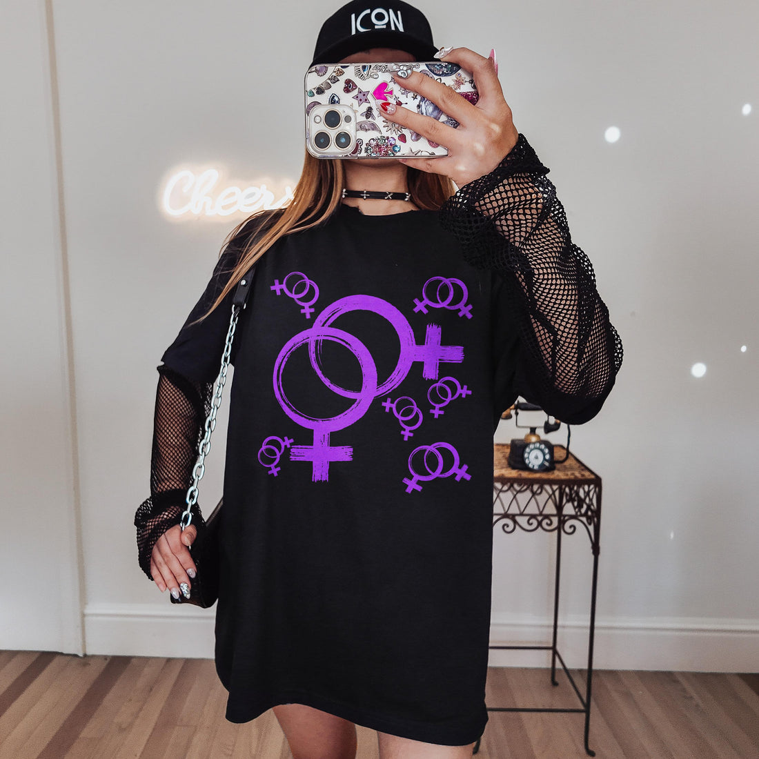 Black t-shirt with repeating purple Venus symbols and &amp;quot;ICON&amp;quot; hat.