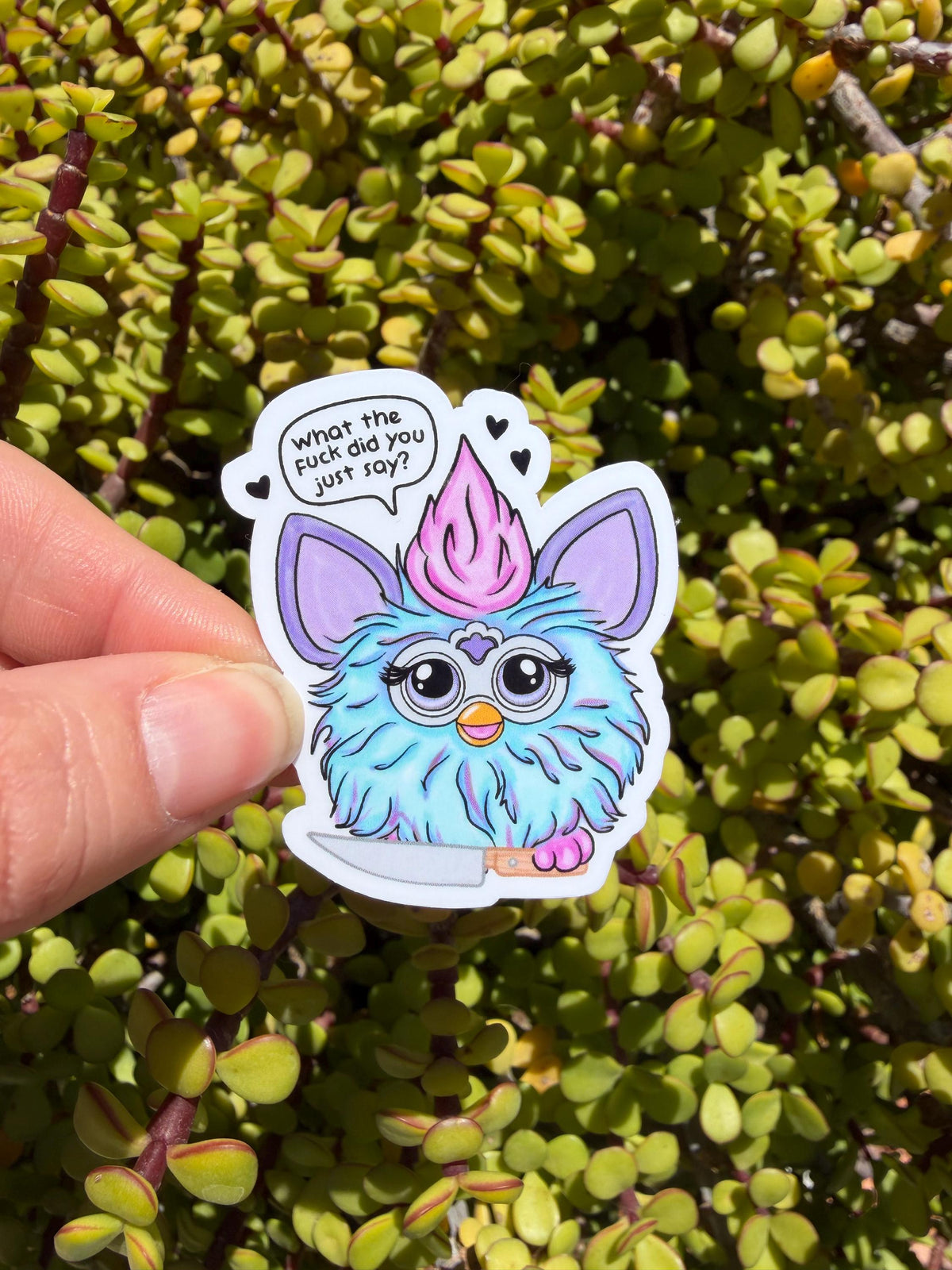 May include: A sticker featuring a cartoon creature with blue fur, large eyes, and a pink tuft of hair. The creature is holding a knife and has the text &amp;quot;what the fuck did you just say?&amp;quot; in a speech bubble.