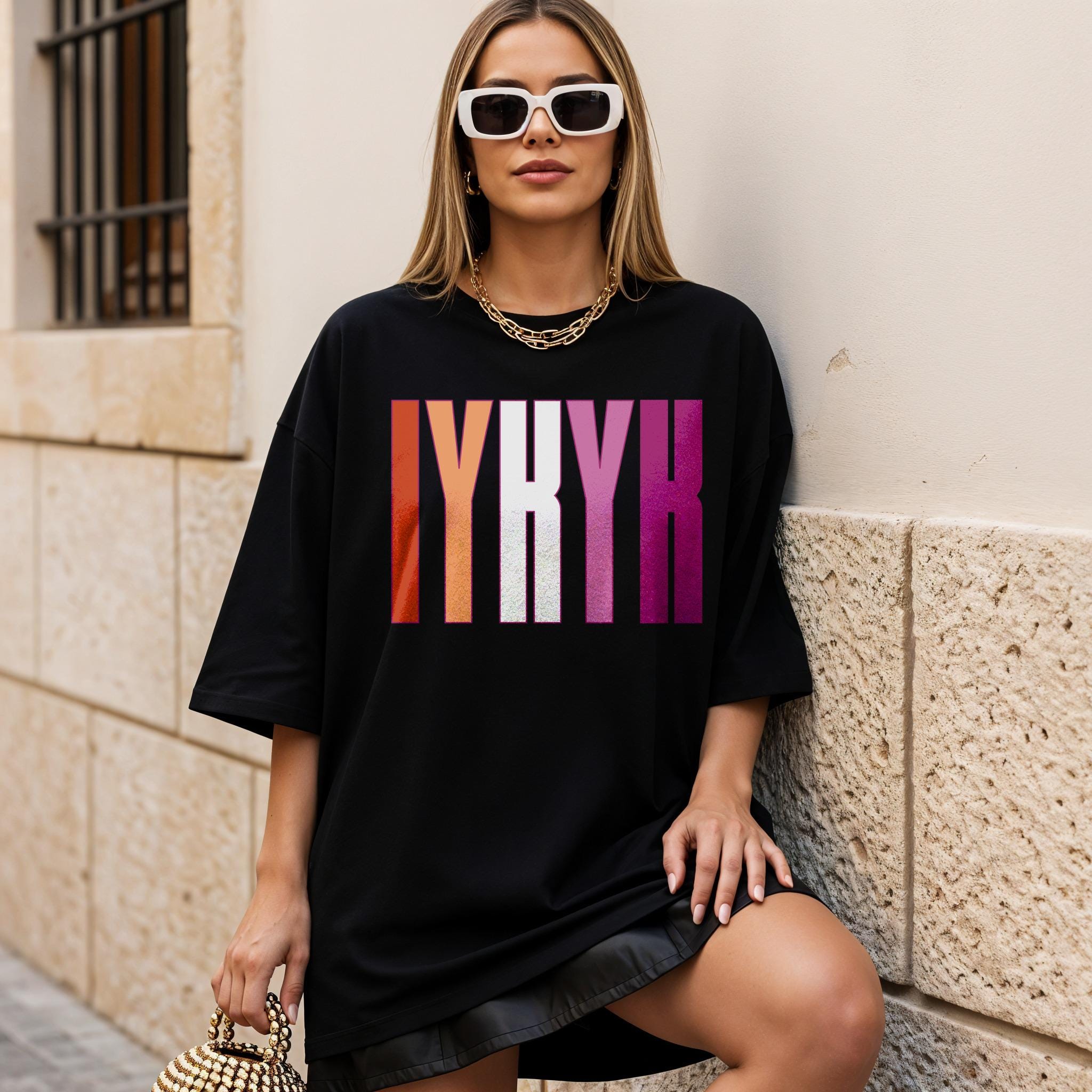 Woman wearing black t-shirt with colorful &amp;quot;LYRK&amp;quot; text and gold chain.