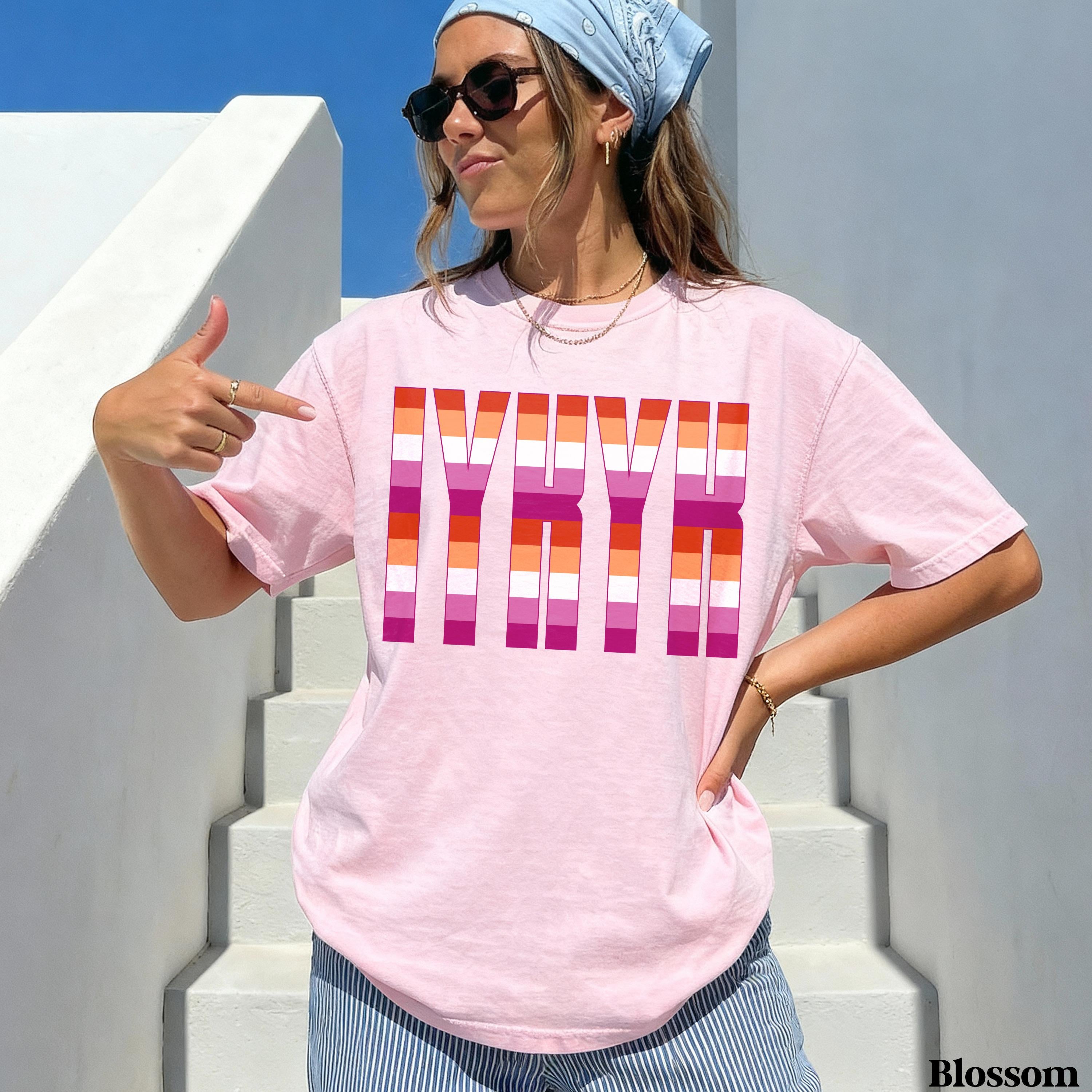 Woman wearing pink t-shirt with lesbian flag stripes spelling &amp;quot;LGBTQ&amp;quot;.