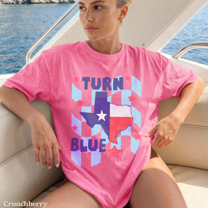Woman wearing a pink t-shirt with &amp;quot;Turn Blue&amp;quot; and a Texas flag star graphic.