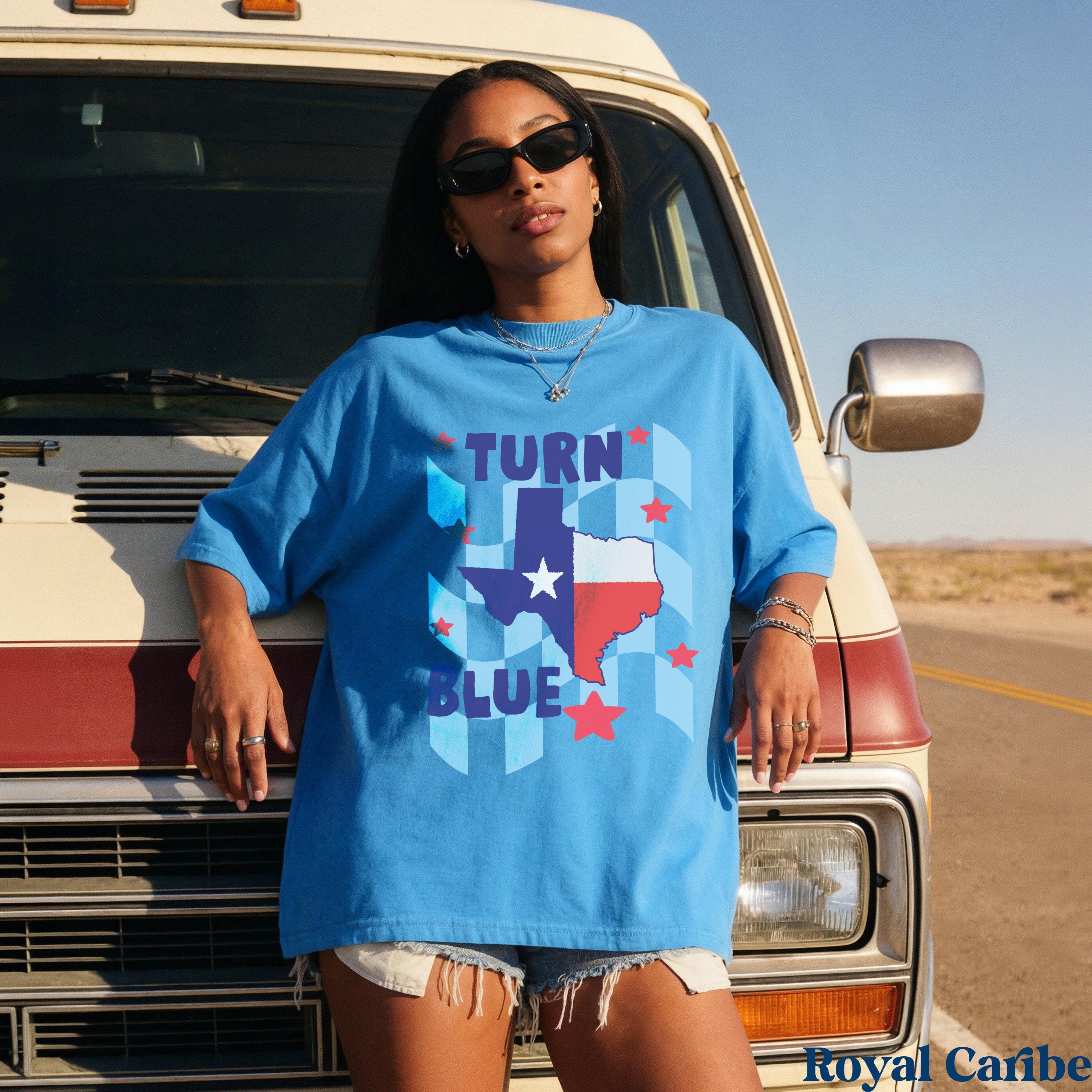 Woman in blue t-shirt with Texas flag and &amp;quot;Turn Blue&amp;quot; text leaning on van.