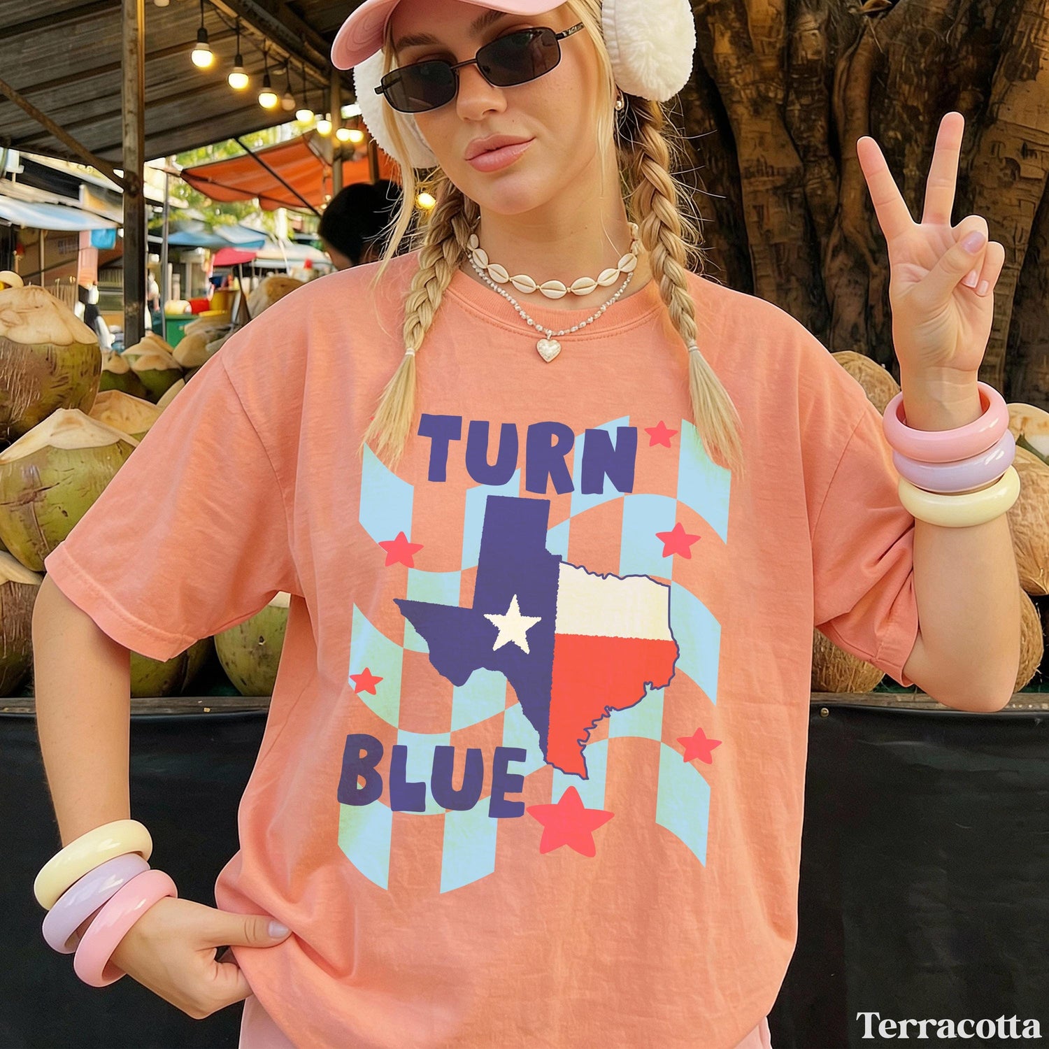 Woman wearing peach t-shirt with &amp;quot;Turn Blue Texas&amp;quot; graphic and peace sign.