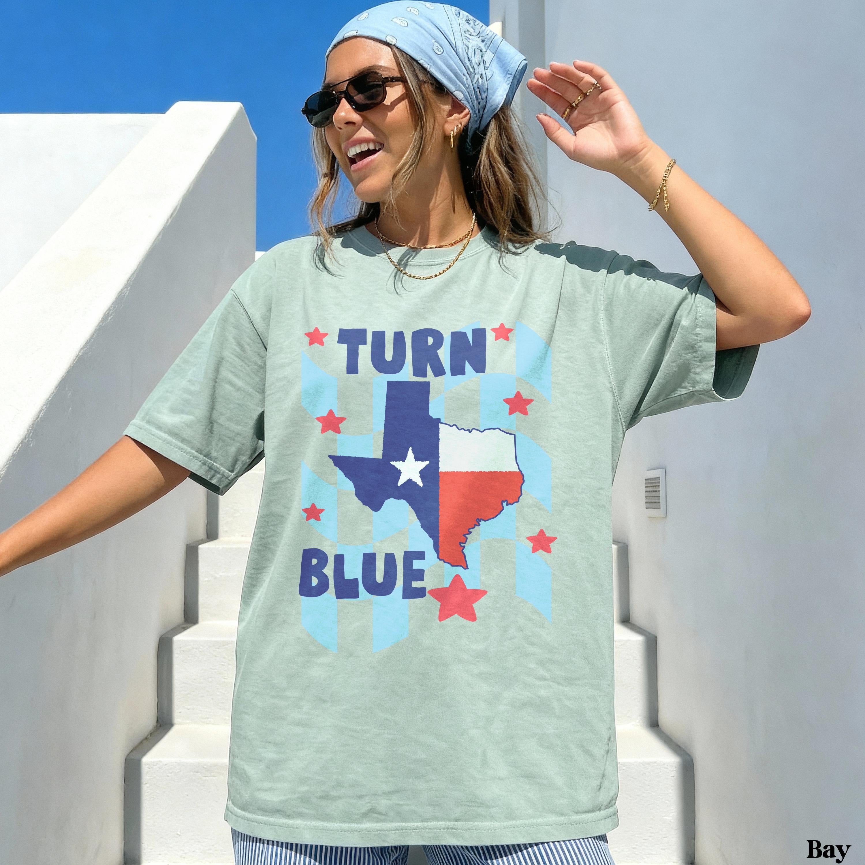 Woman wearing a light green t-shirt with &amp;quot;TURN TEXAS BLUE&amp;quot; and stars.
