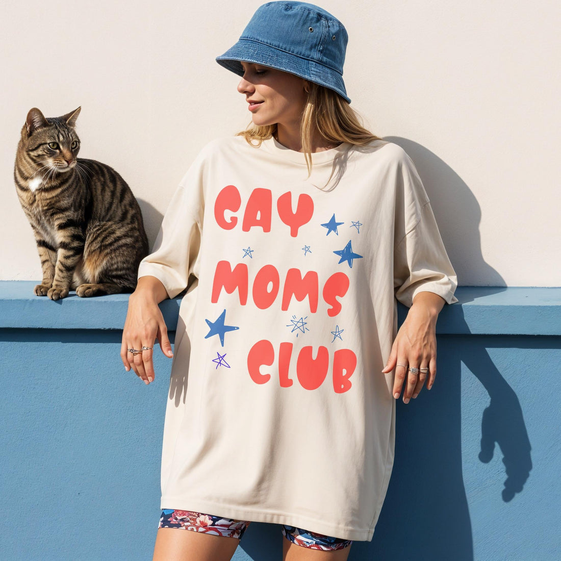 Woman wearing &amp;quot;Gay Moms Club&amp;quot; t-shirt, with cat sitting beside her.