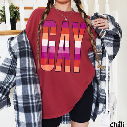 T-shirt with &amp;quot;GAY&amp;quot; text in lesbian flag colors, worn by a person with plaid jacket.