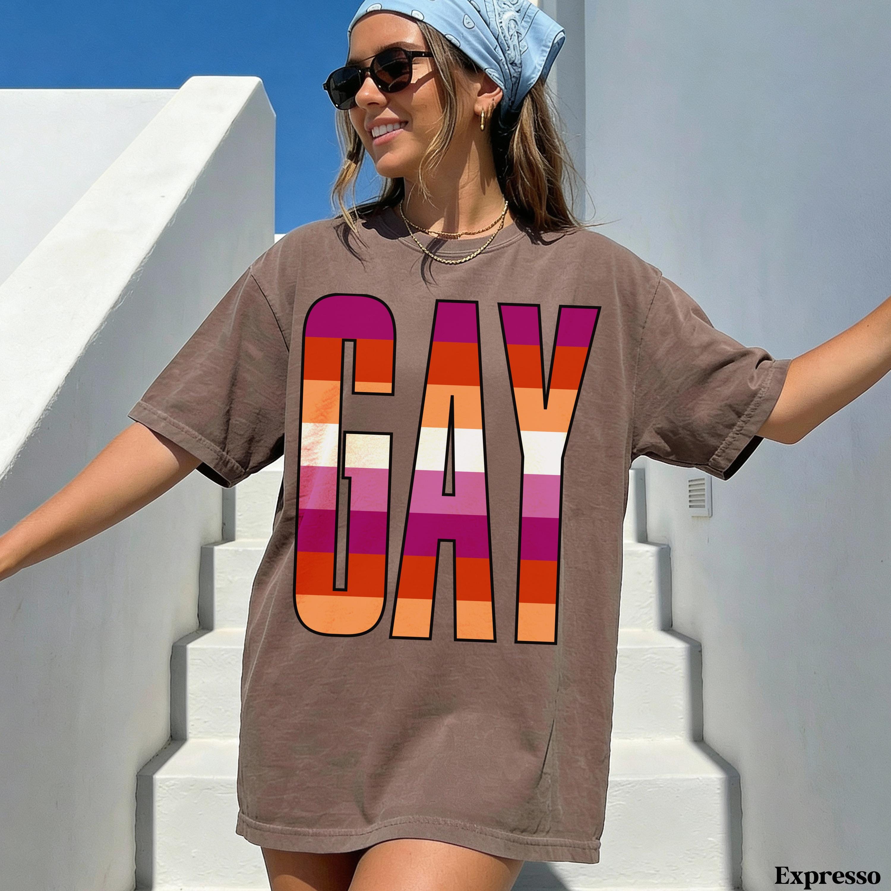 Brown t-shirt with &amp;quot;GAY&amp;quot; in rainbow stripes, white text &amp;quot;Expresso&amp;quot; in corner.