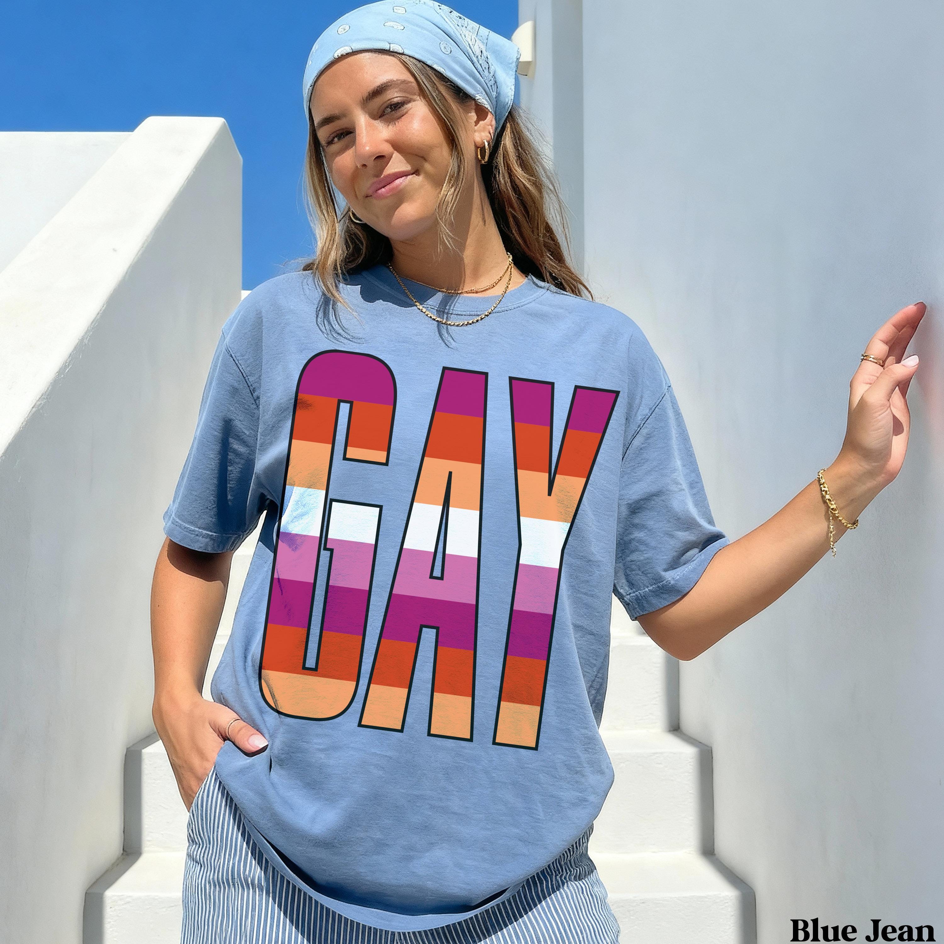 Blue t-shirt with &amp;quot;GAY&amp;quot; in rainbow stripes, worn by a woman.