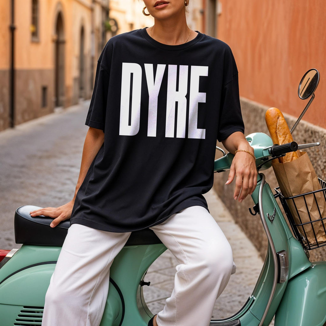 Black t-shirt with &amp;quot;DYKE&amp;quot; in white block letters, worn by a person on a scooter.