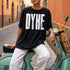 Black t-shirt with "DYKE" in white block letters, worn by a person on a scooter.