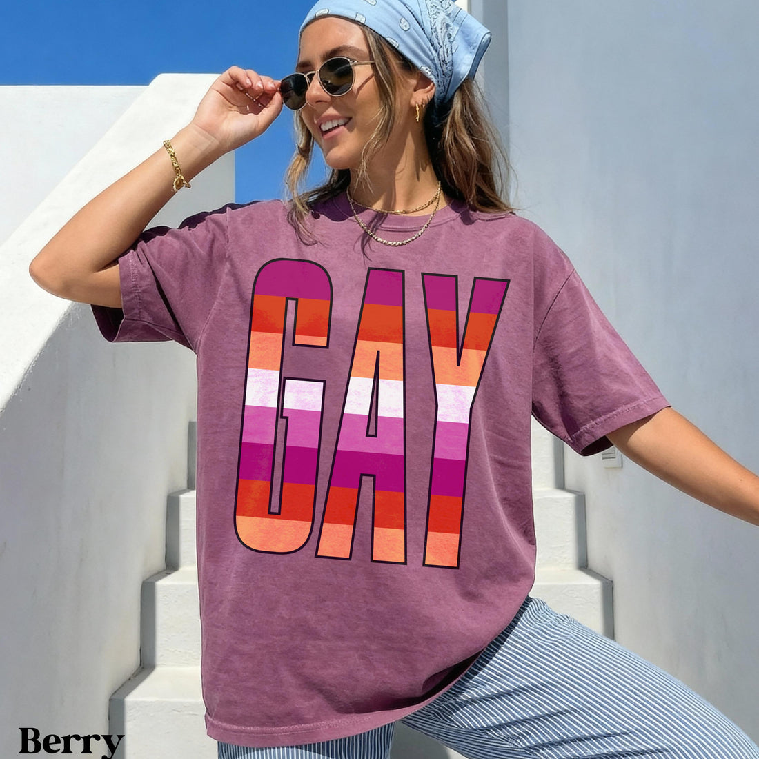 Berry t-shirt with &amp;quot;GAY&amp;quot; in colorful stripes, worn by a smiling woman.