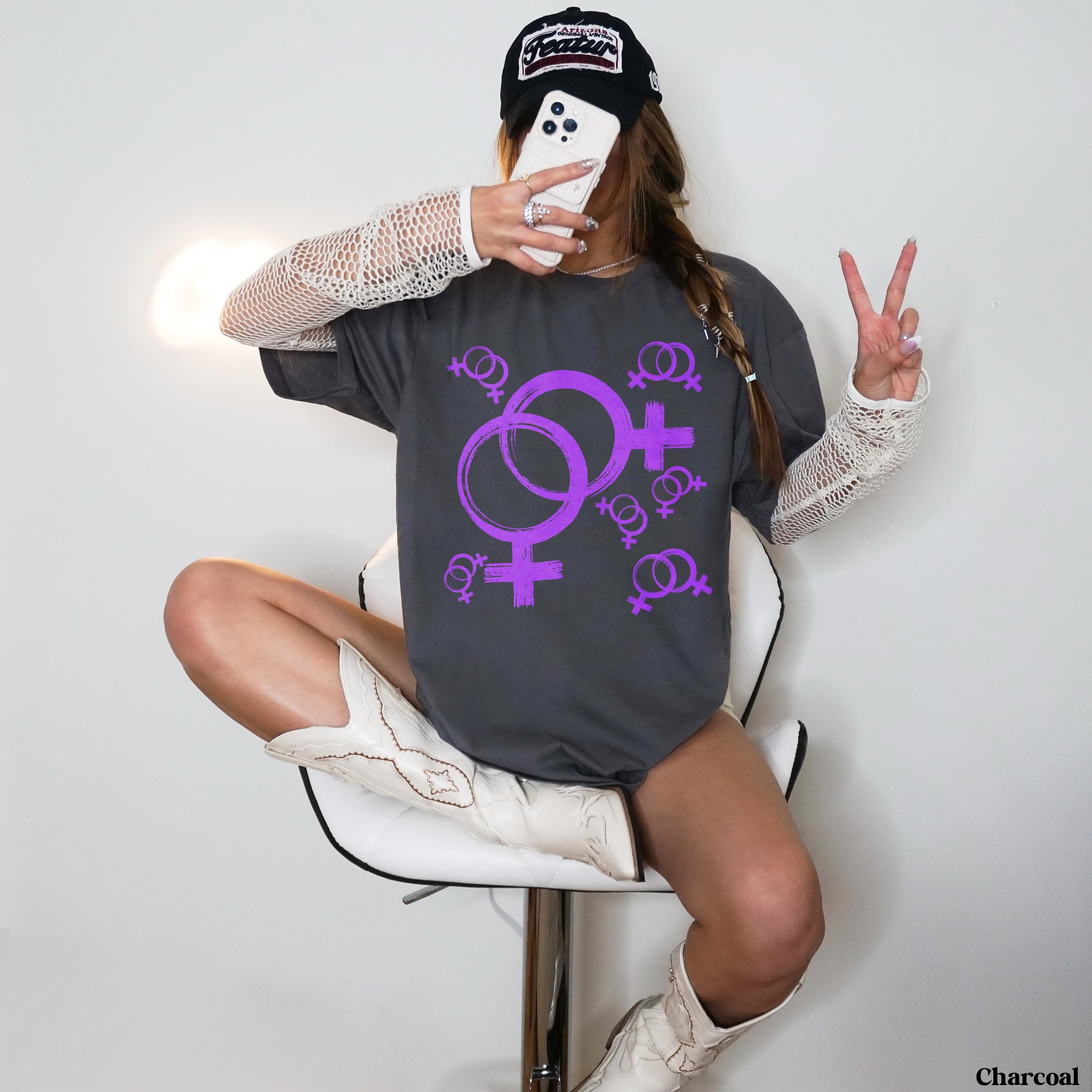 Dark grey t-shirt with purple Venus symbols design, worn by a woman.