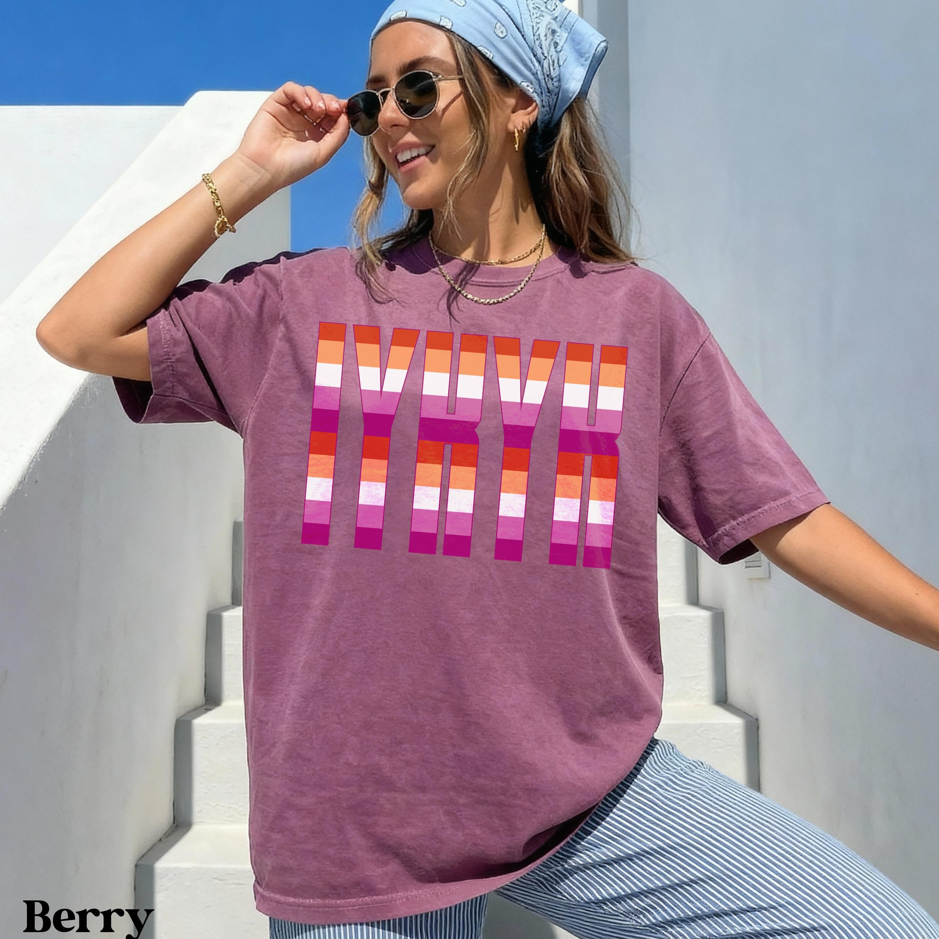 Burgundy t-shirt with bold pink and orange stripes spelling &amp;quot;PRIDE&amp;quot;.