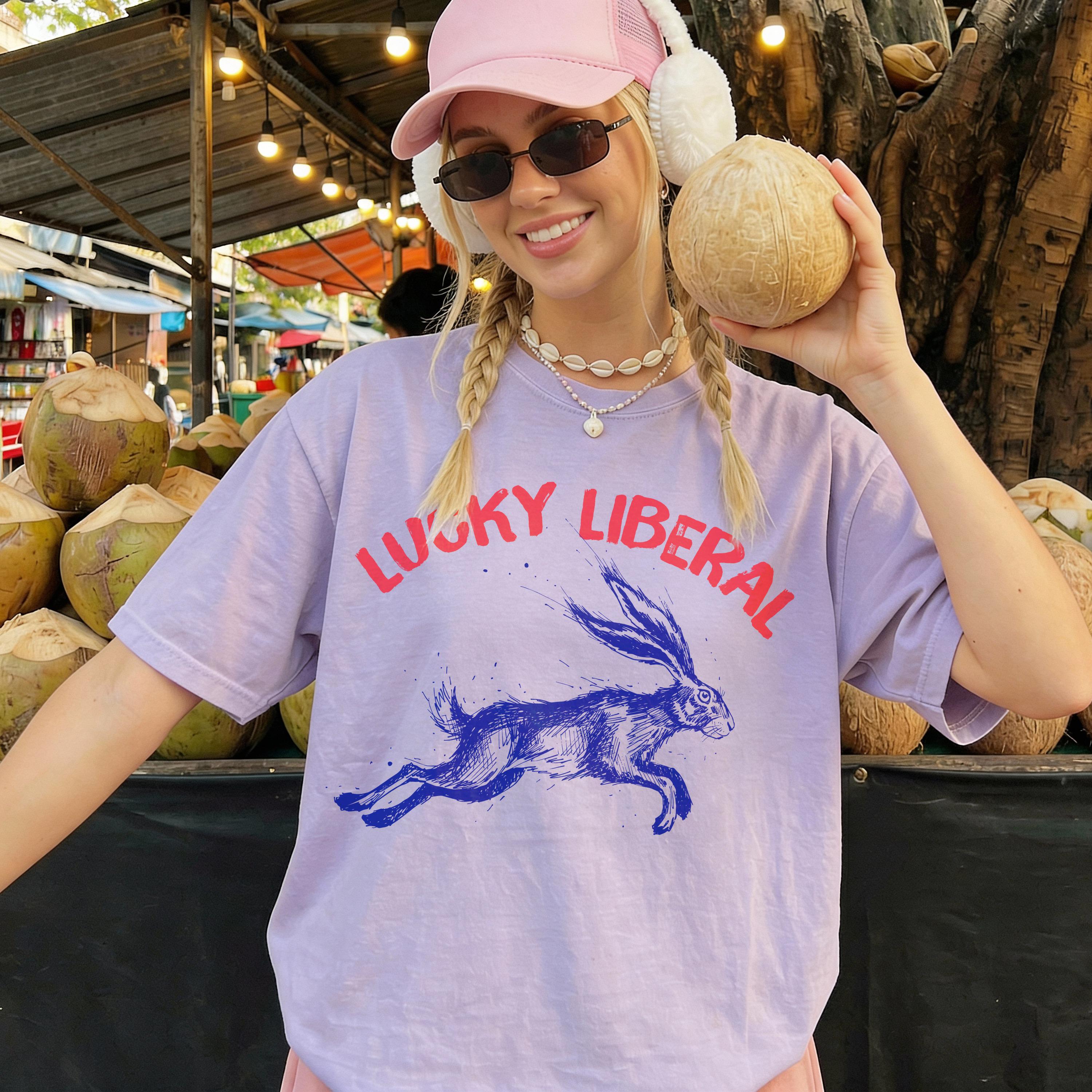 Woman wearing a light purple t-shirt with a blue rabbit and text.