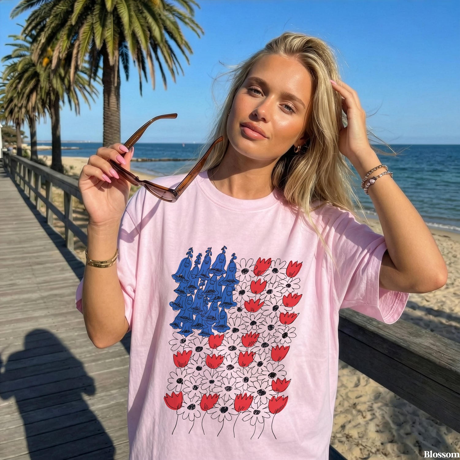 Woman wearing pink t-shirt with abstract red, white, and blue floral design.