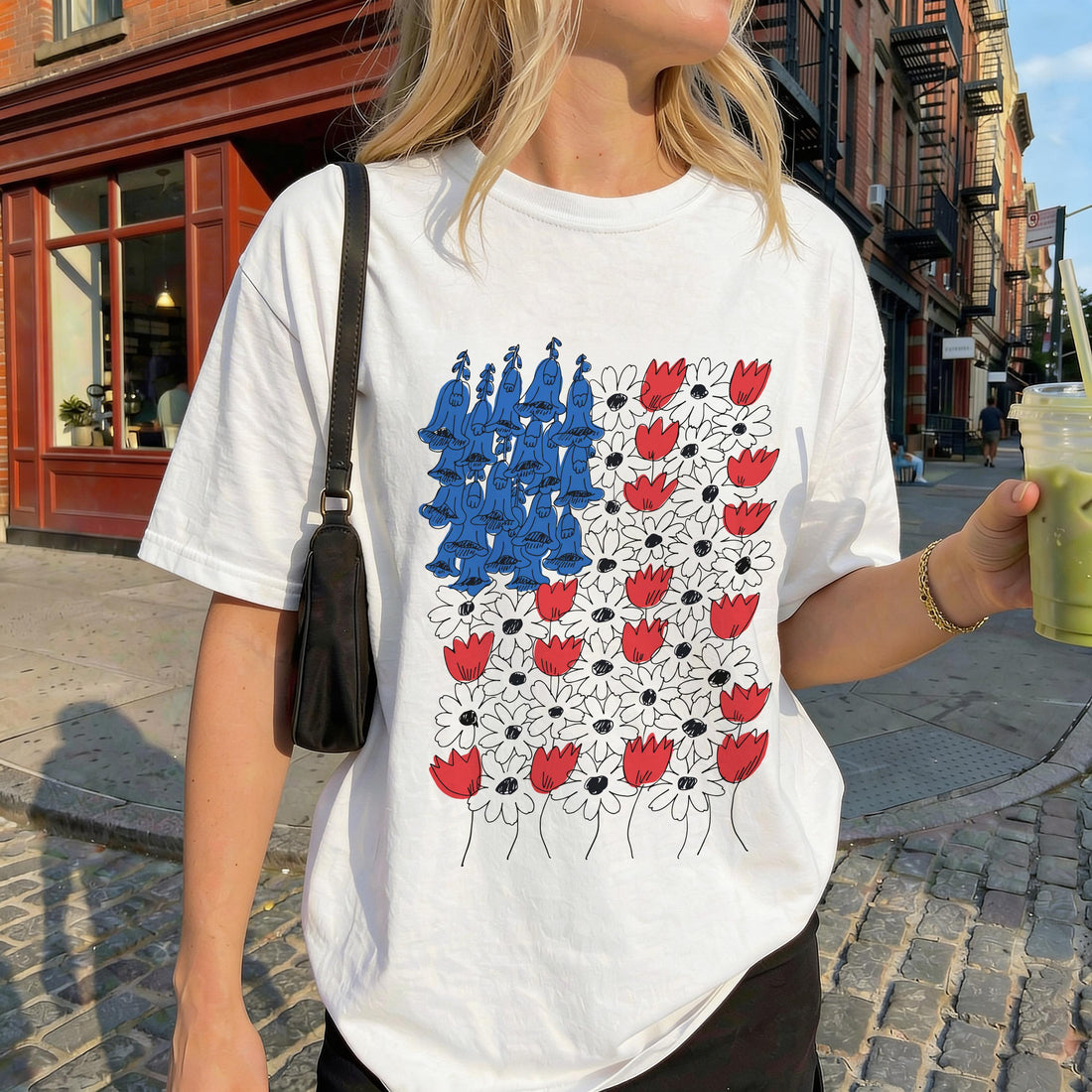 White t-shirt with red and white flowers and blue abstract shapes.