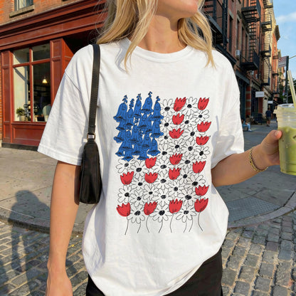 White t-shirt with red and white flowers and blue abstract shapes.