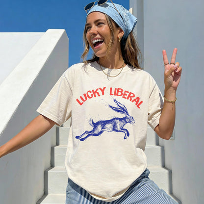 Cream graphic t-shirt with blue &amp;quot;Lucky Liberal&amp;quot; text and a running rabbit.