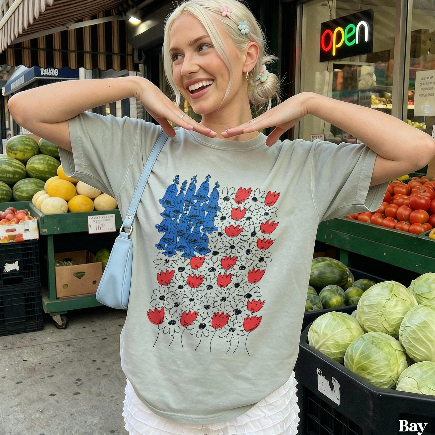 Woman wearing a gray t-shirt with a blue and red floral design.