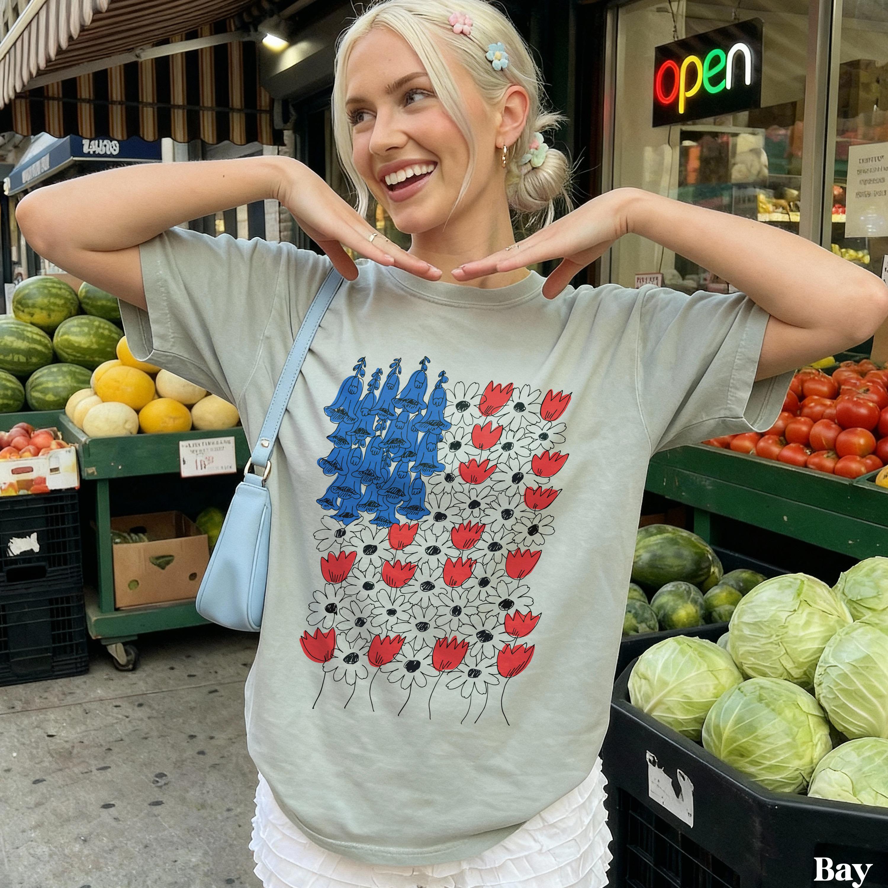 Woman wearing a gray t-shirt with a blue and red floral design.