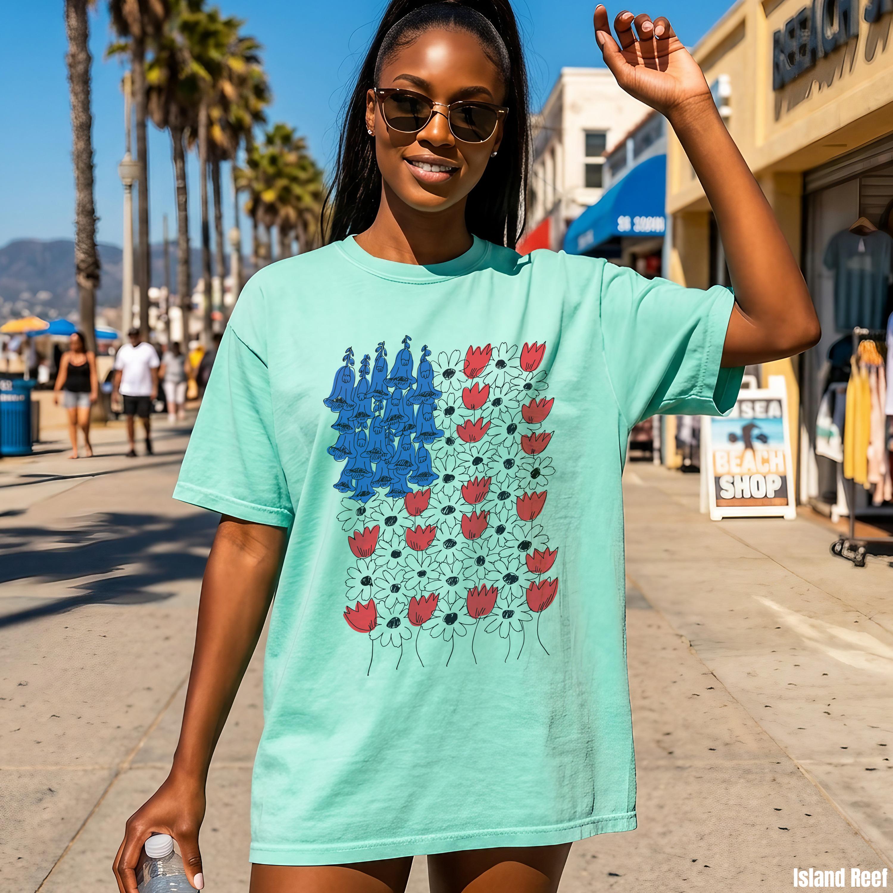 Teal t-shirt with red tulips and blue abstract shapes forming an American flag pattern.