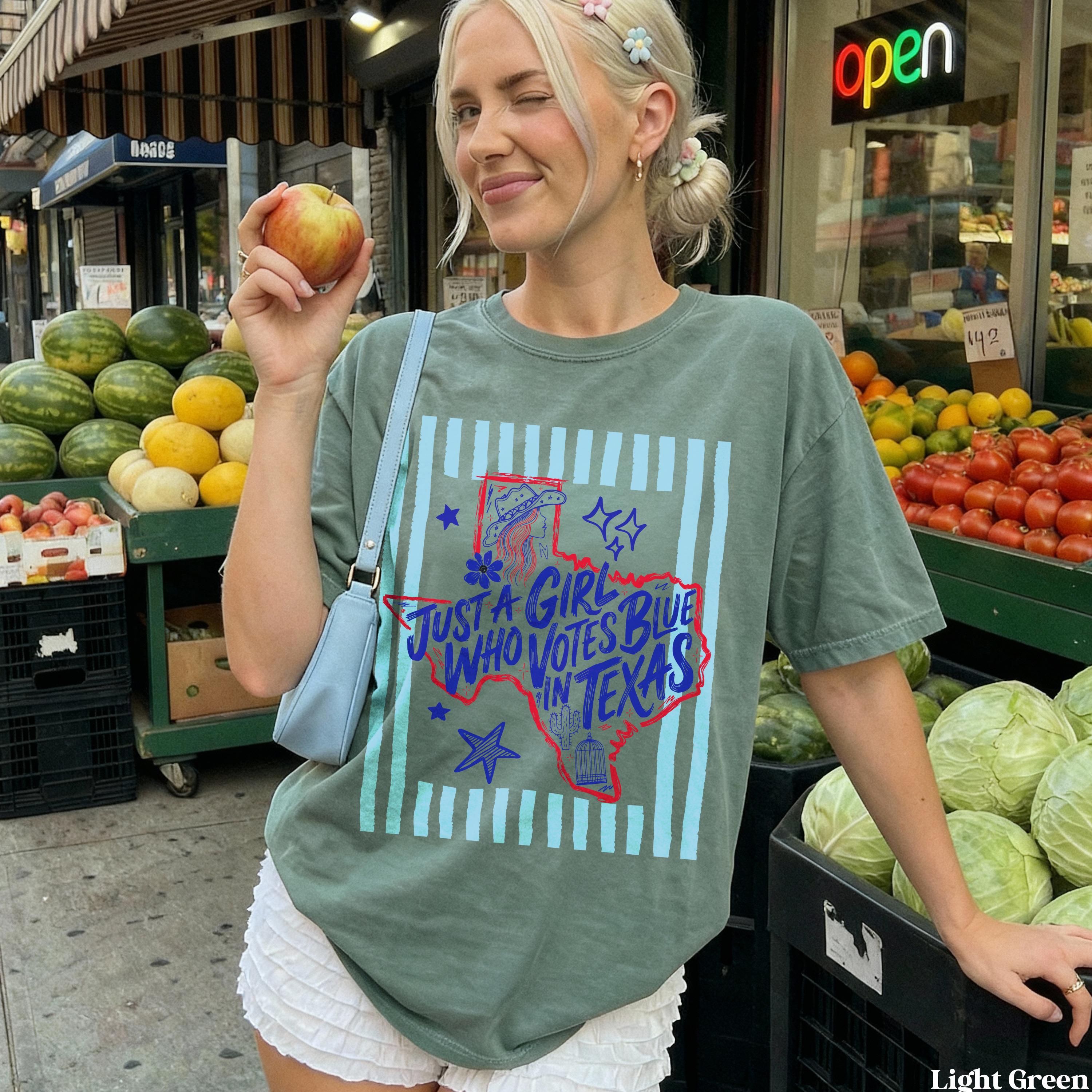 Woman in light green t-shirt with &amp;quot;Just a girl who votes blue in Texas&amp;quot; graphic.
