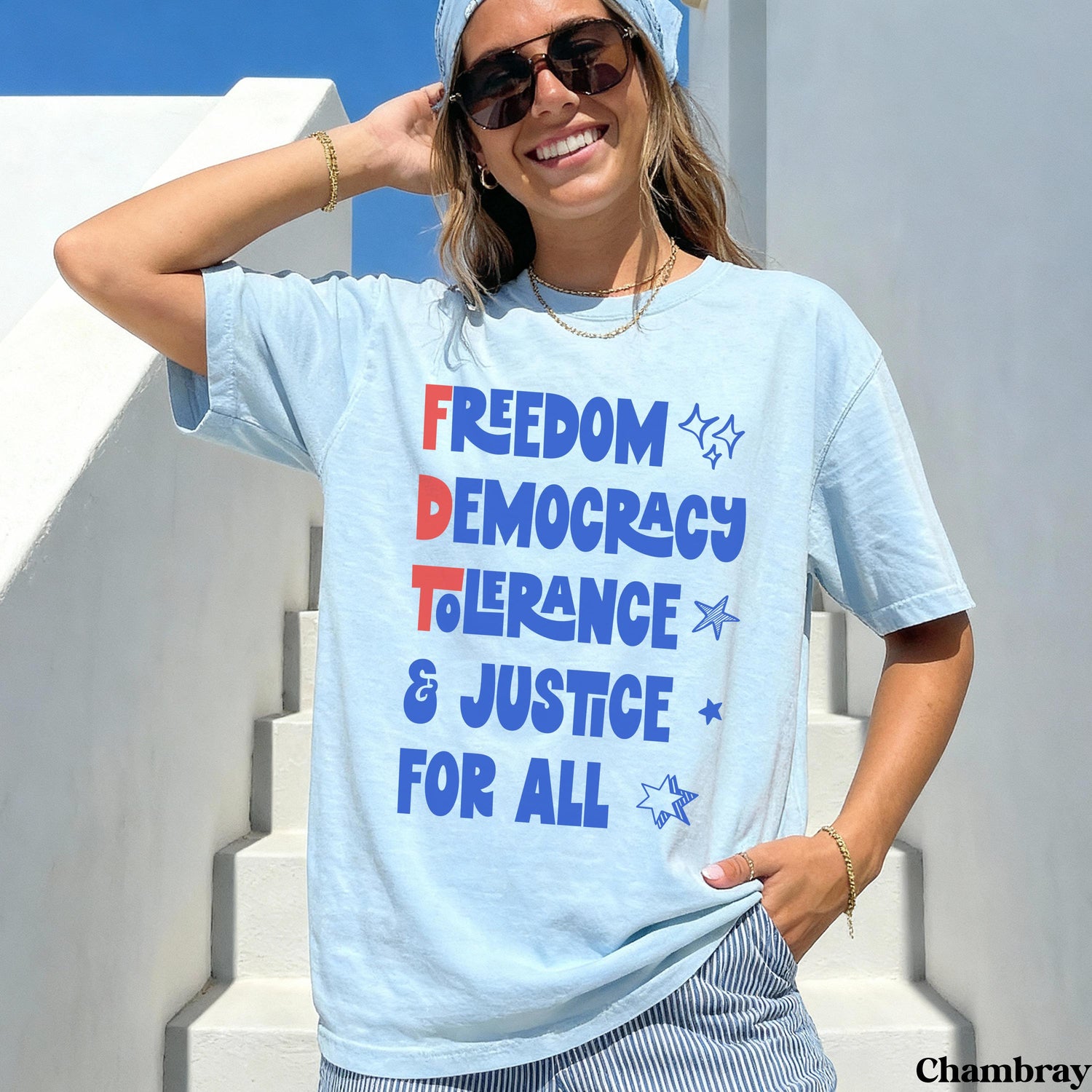 Light blue t-shirt with red, white, and blue text &amp;quot;FREEDOM DEMOCRACY TOLERANCE JUSTICE FOR ALL&amp;quot;.