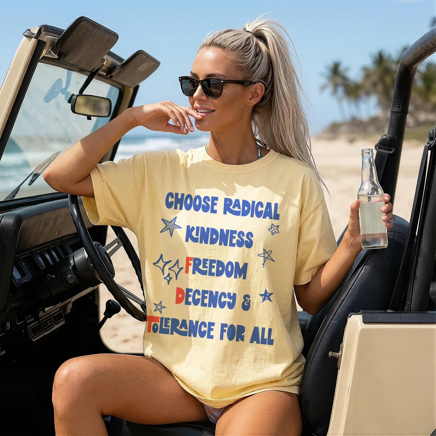 Woman in yellow t-shirt with &amp;quot;Choose Radical Kindness Freedom Decency Tolerance For All&amp;quot; text, sitting in a Jeep.