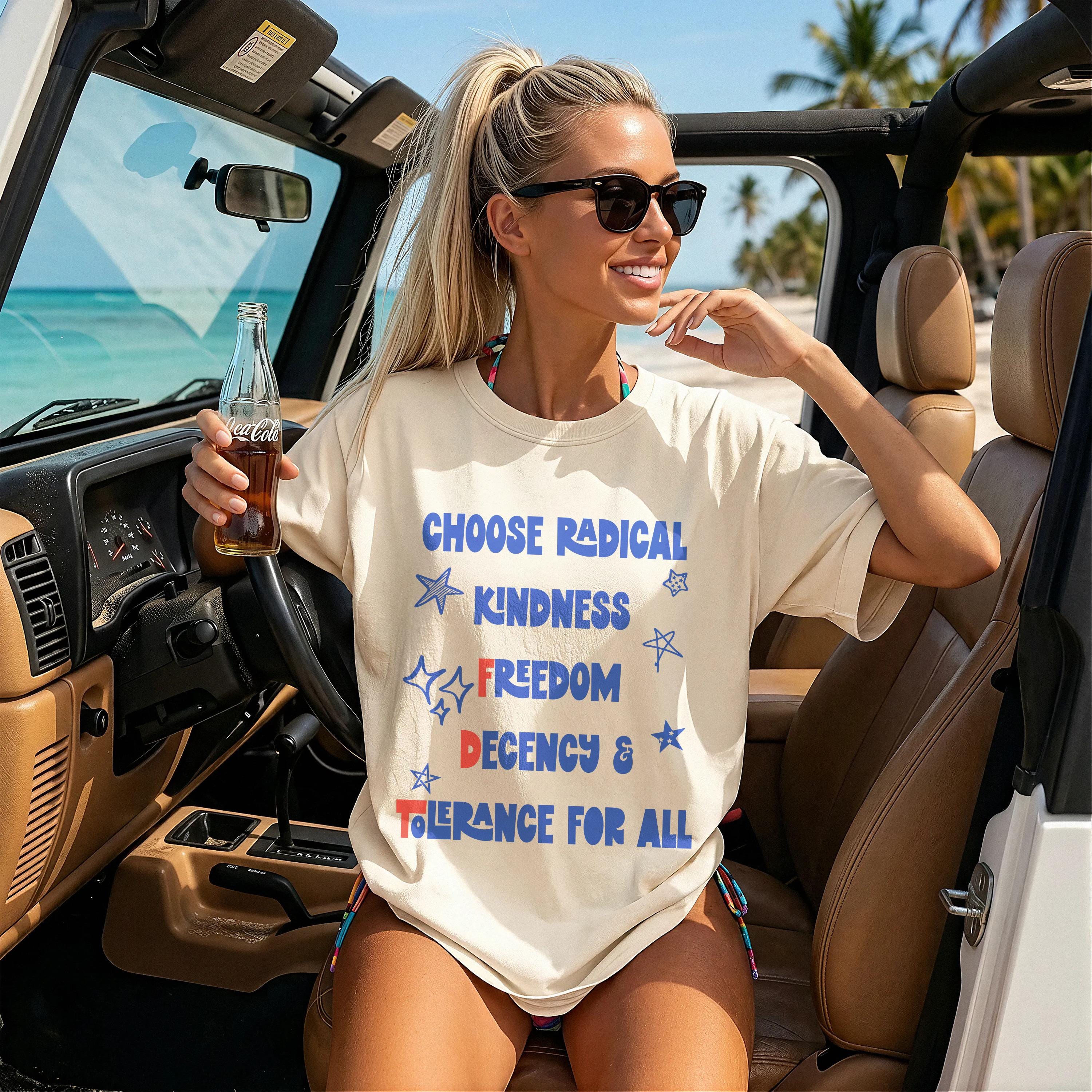 Woman in Jeep wearing cream t-shirt with &amp;quot;Choose Radical Kindness Freedom Decency &amp; Tolerance For All&amp;quot; text.