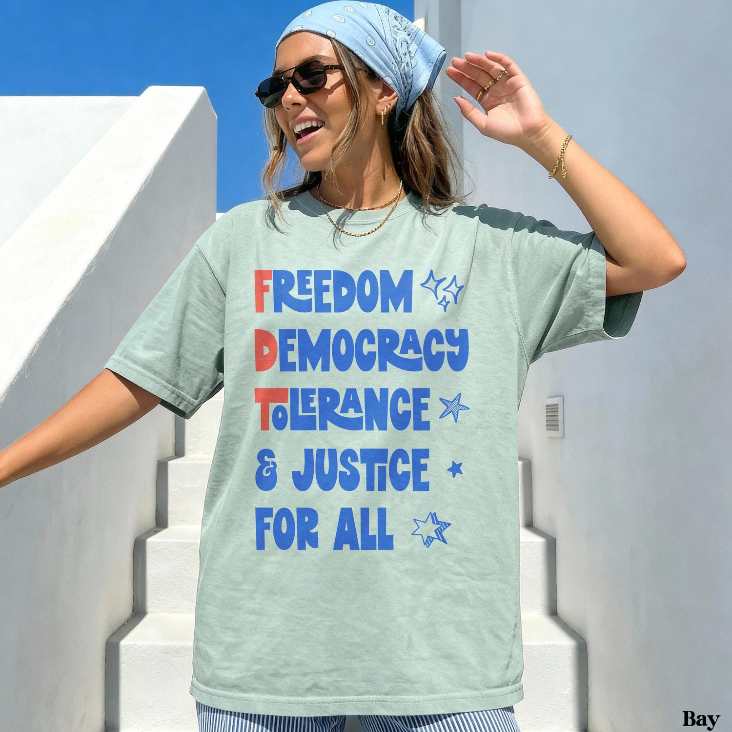 Light blue graphic tee with &amp;quot;FREEDOM DEMOCRACY TOLERANCE &amp; JUSTICE FOR ALL&amp;quot; text.