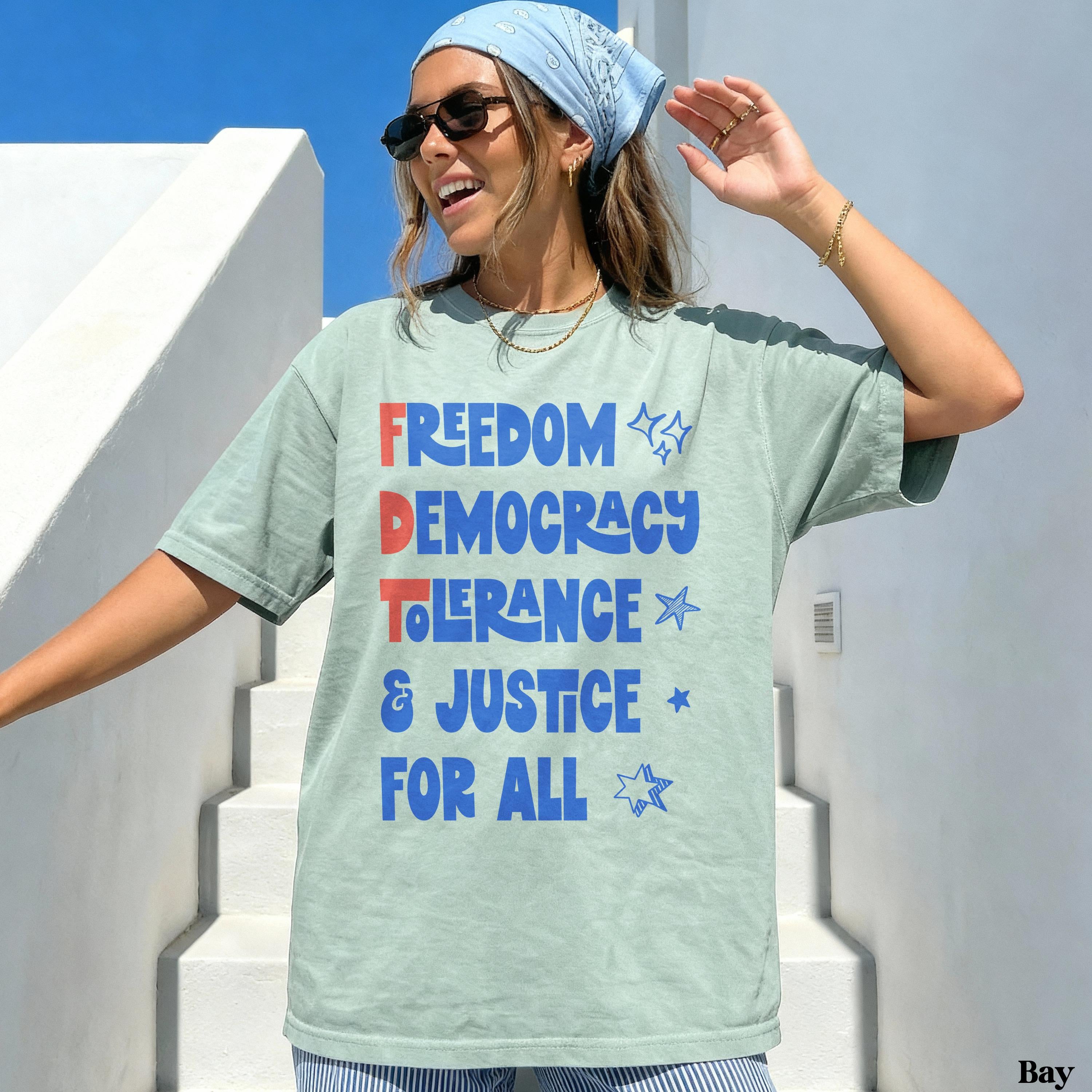 Light blue graphic tee with &amp;quot;FREEDOM DEMOCRACY TOLERANCE &amp; JUSTICE FOR ALL&amp;quot; text.
