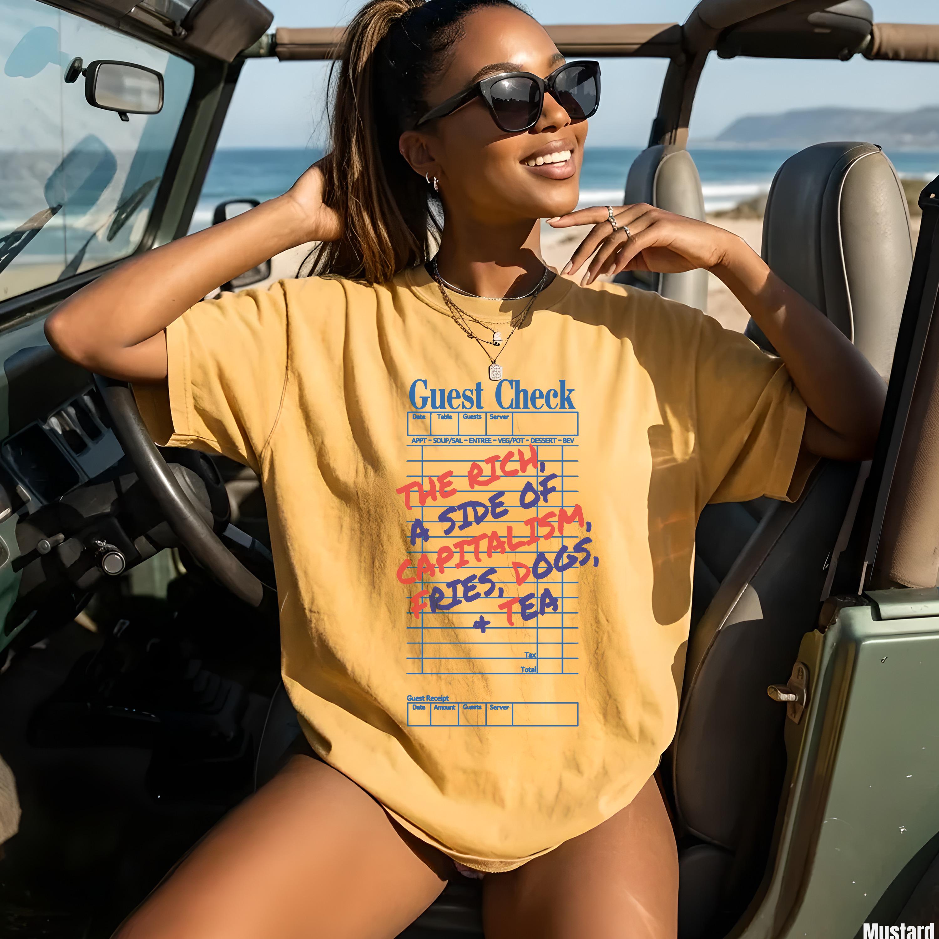 Woman wearing mustard graphic tee with &amp;quot;Guest Check&amp;quot; and capitalism-themed order.