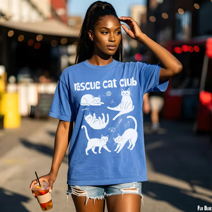 Woman in blue t-shirt with &amp;quot;Rescue Cat Club&amp;quot; and cat designs.
