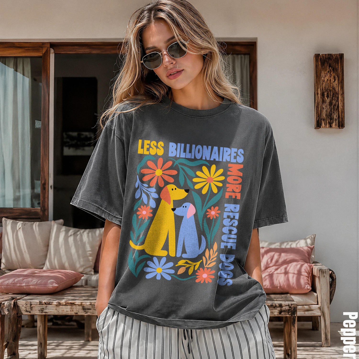 Woman wearing a dark grey t-shirt with &amp;quot;LESS BILLIONAIRES MORE RESCUE DOGS&amp;quot; and floral dog graphics.