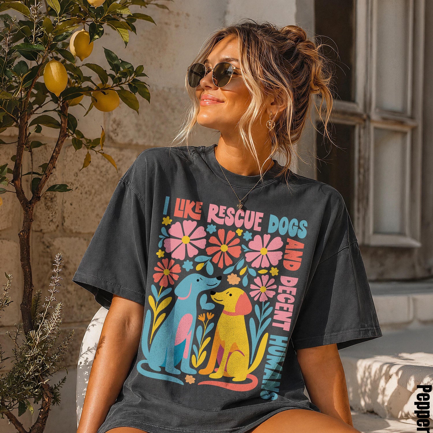 Woman wearing a dark t-shirt with colorful floral design and &amp;quot;I like rescue dogs and decent humans&amp;quot; text.