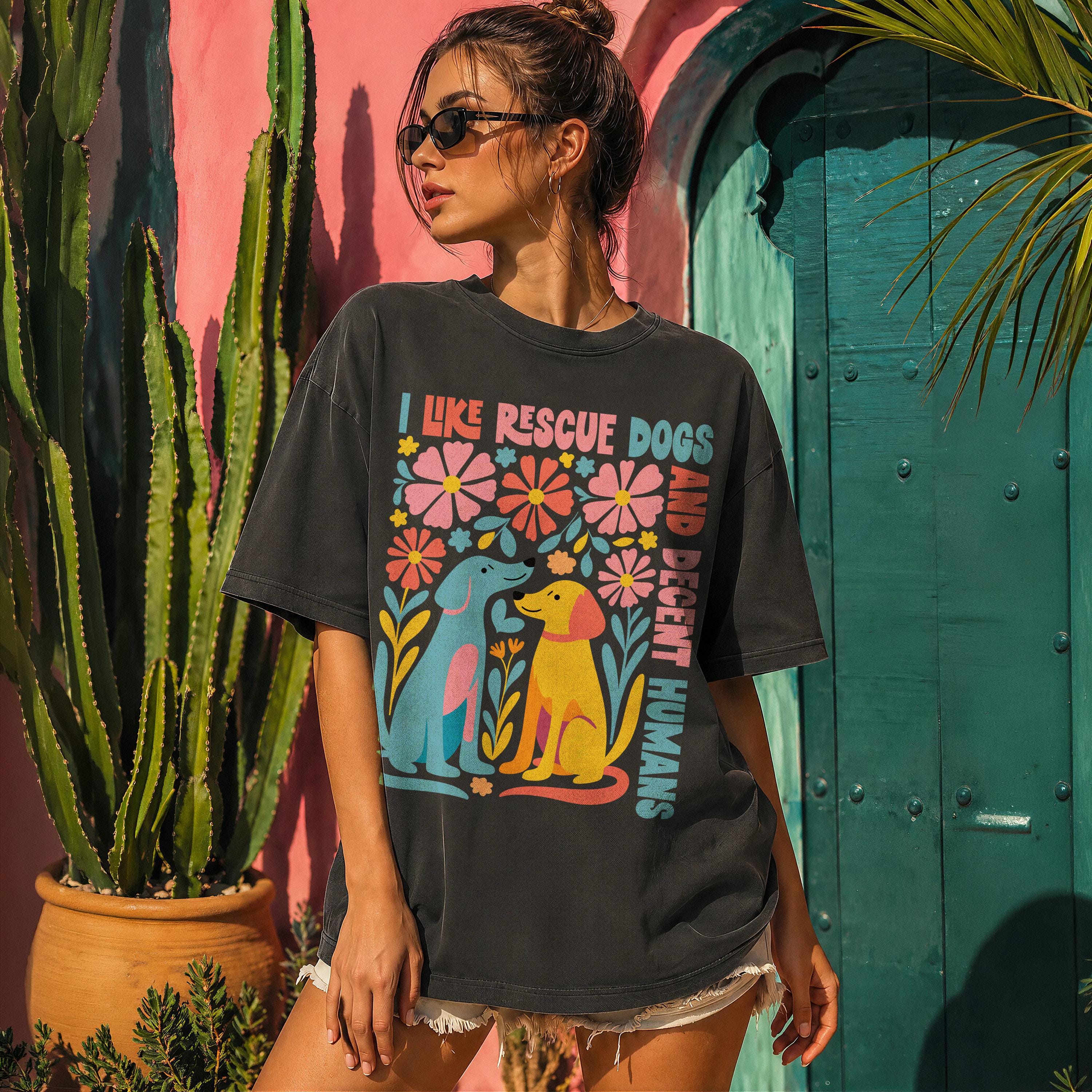 Woman wearing black t-shirt with colorful floral and dog graphic.