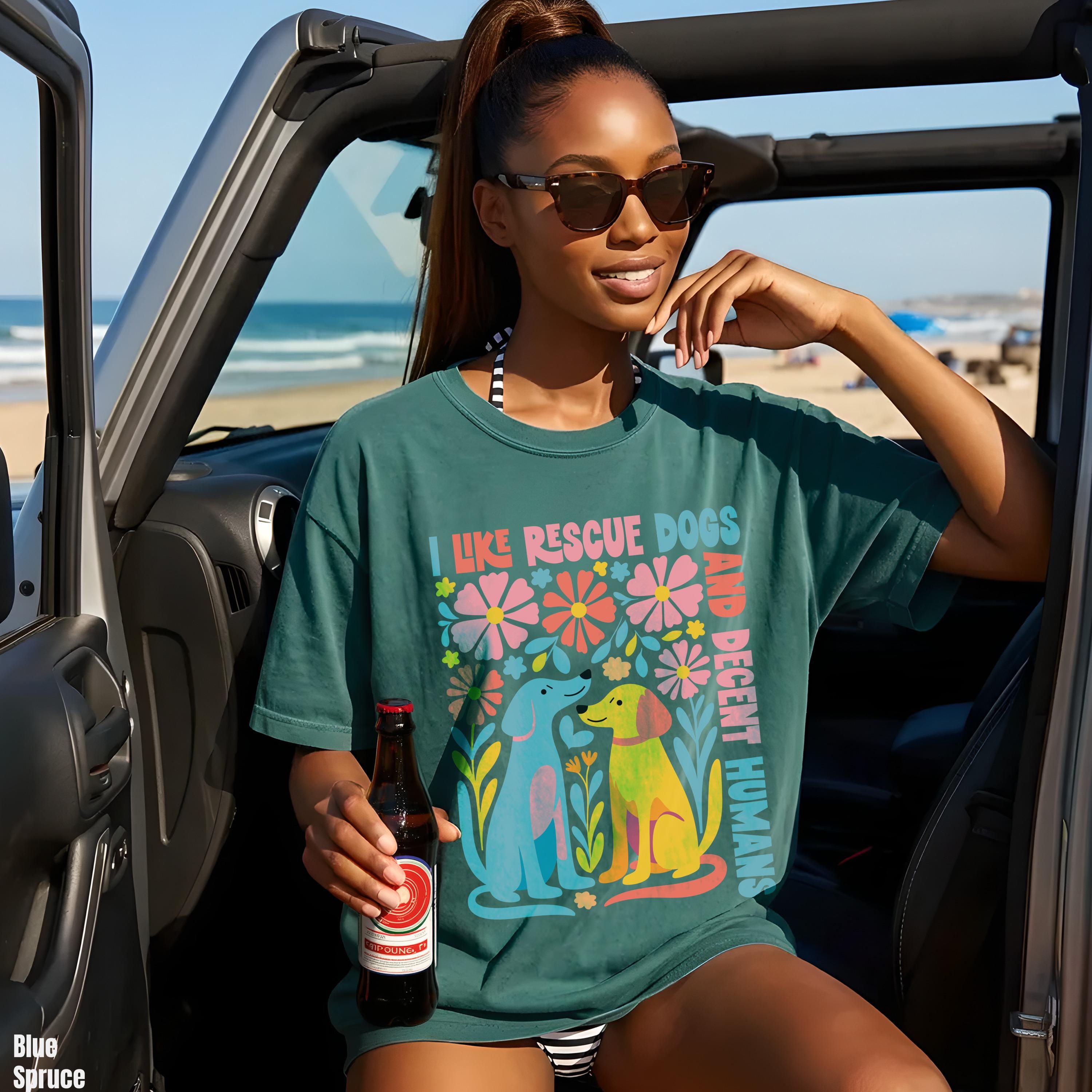 Woman in teal shirt with &amp;quot;I like rescue dogs and decent humans&amp;quot; graphic and floral art.