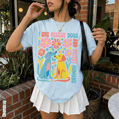 Light blue t-shirt with colorful floral design and dogs that reads &amp;quot;I Like Rescue Dogs and Their Humans&amp;quot;.