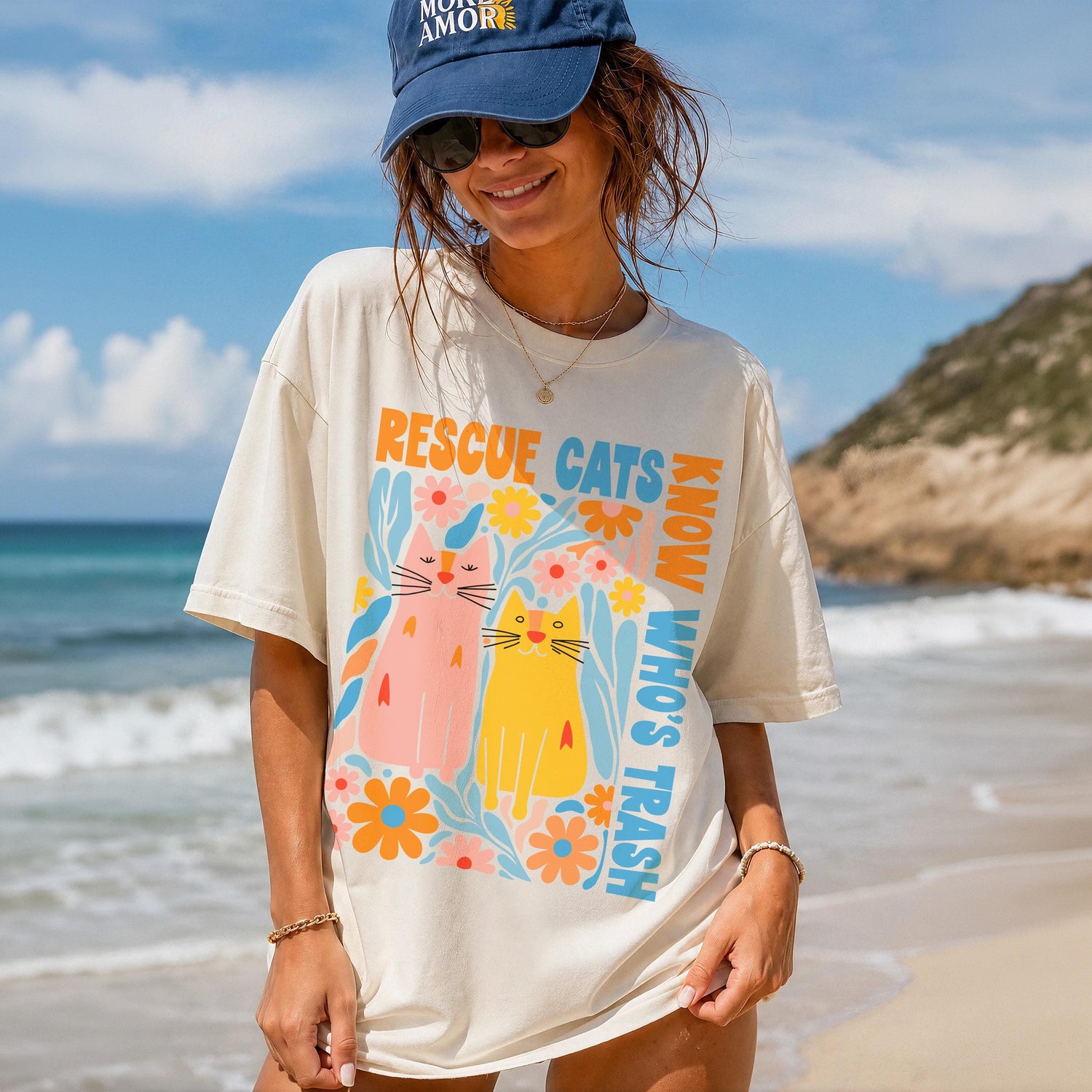 Woman wearing a cream t-shirt with colorful cats and text &amp;quot;RESCUE CATS KNOW WHO&amp;