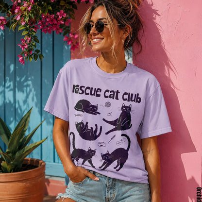 Woman wearing a purple t-shirt with black cat illustrations and the text &amp;quot;rescue cat club&amp;quot;.